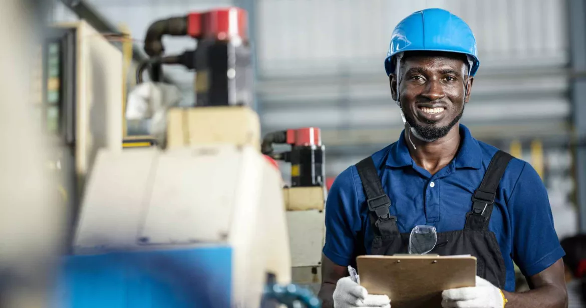 Construction worker in blue facing camera and smiling