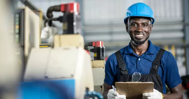 Construction worker in blue facing camera and smiling