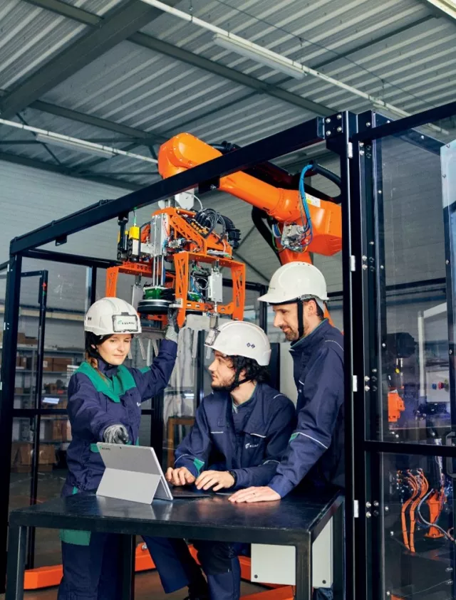 Equans workers around computer